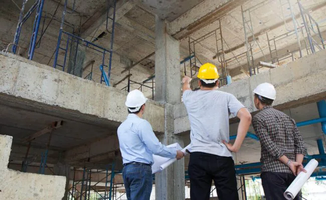 Projektbesprechung Projektbesprechung von drei Männern mit Schutzhelm auf einer Großbaustelle